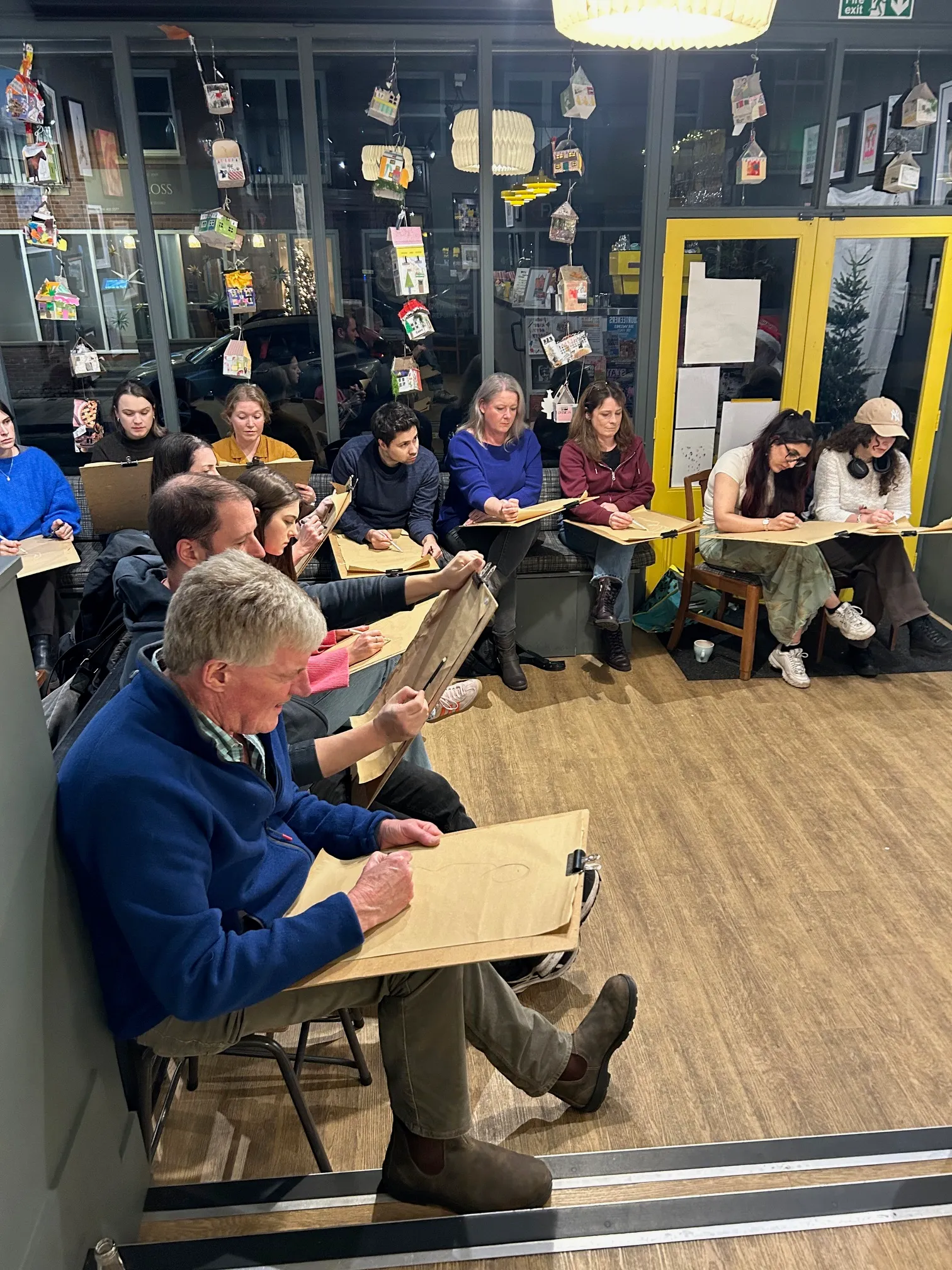 Adults working on their artwork during a class at Art Club